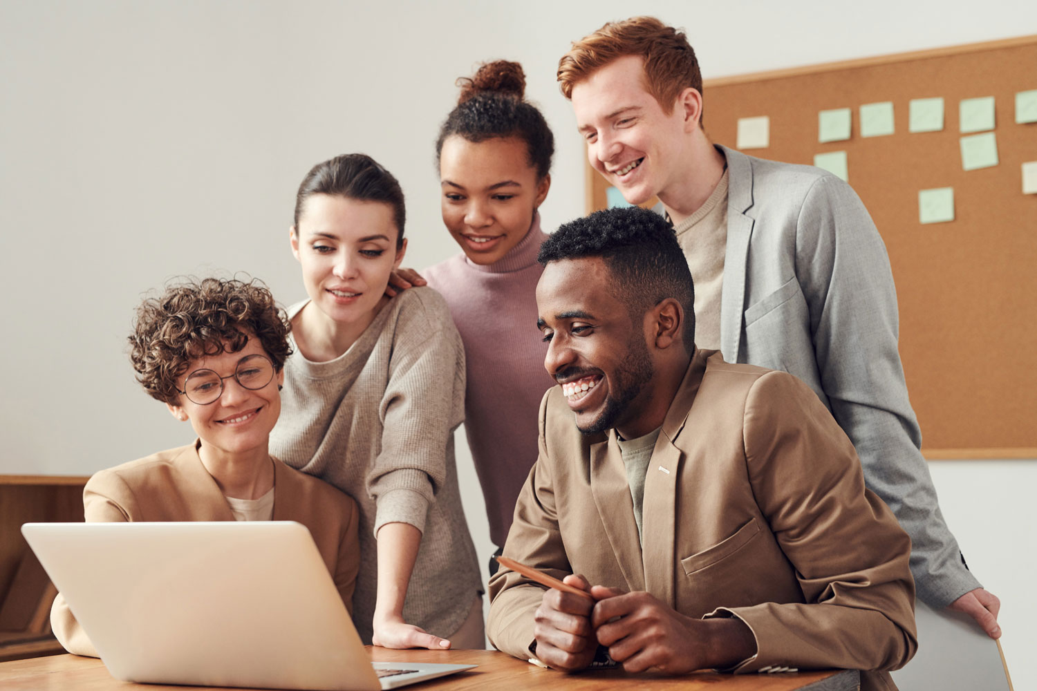 group of happy people and laptop